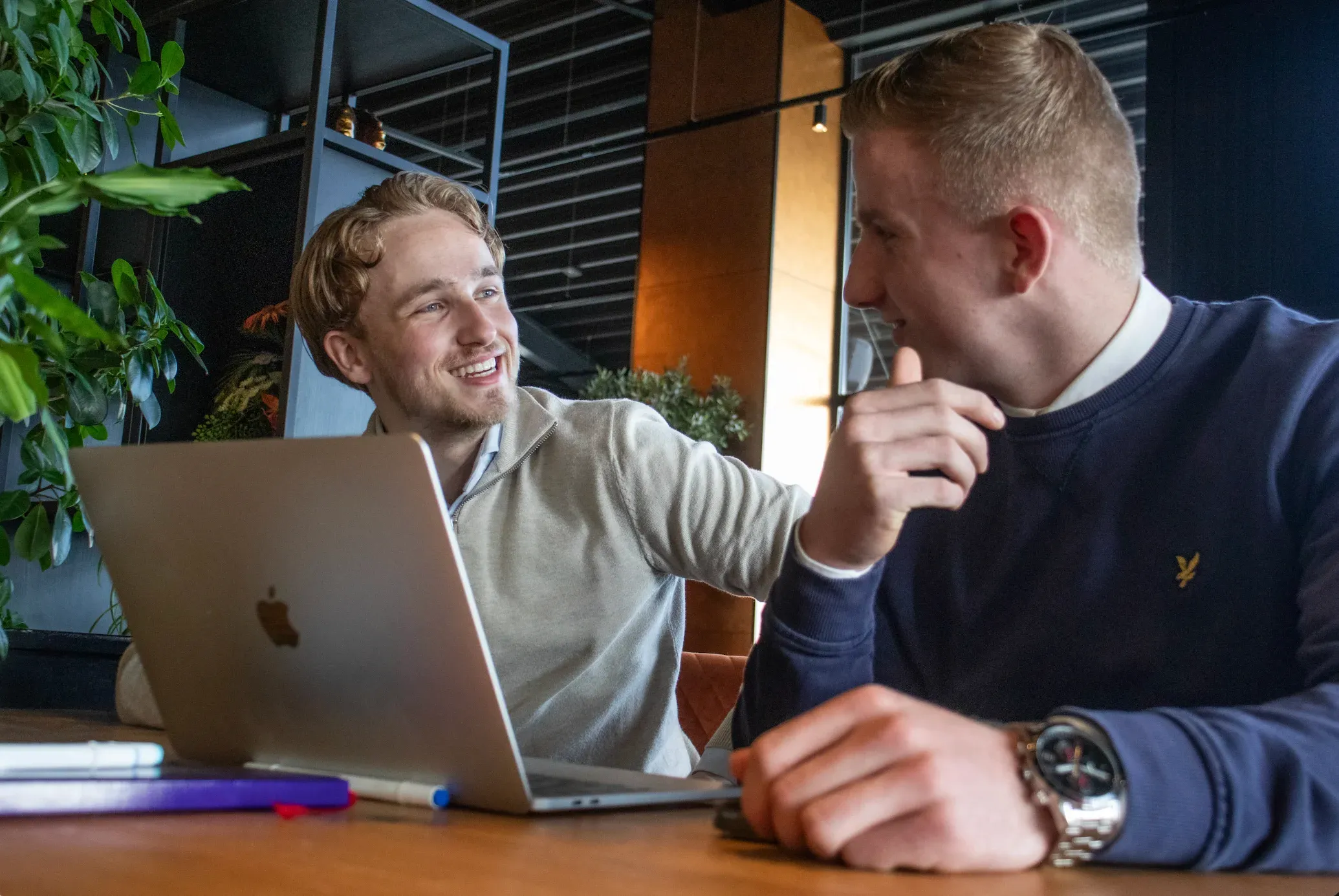 Bram Zomer legt aan een klant iets uit bij een laptop
